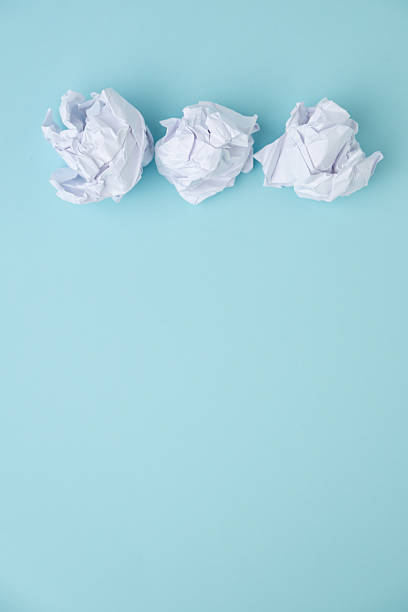 istock Crumpled paper balls on blue background 2249640581