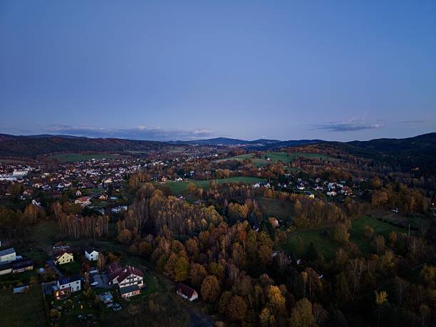 istock nighttime aerial perspective showcasing illuminated homes amongst rolling hills and lush clusters of trees 2249643125