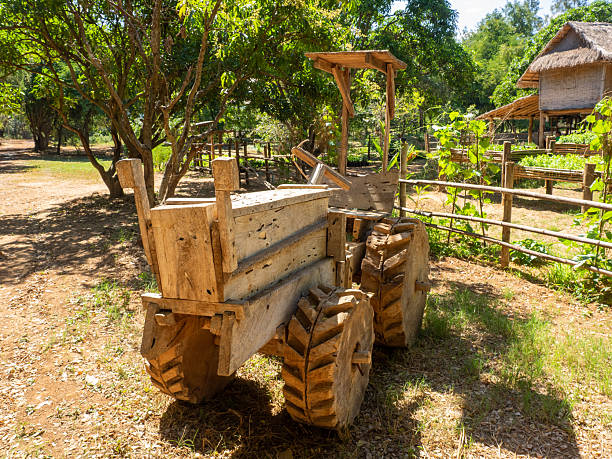 Vintage green tractor in rustic log and plank barn lean-to.