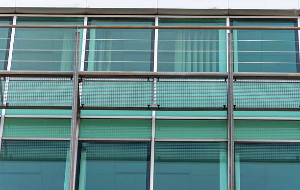 istock Glass facade of a building with metal supports, mesh panels and horizontal structural elements 2249643561