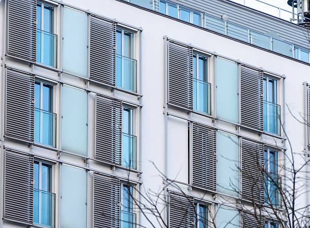istock Modern building facade with vertical blinds, glass panels and large windows in a minimalist style 2249643600