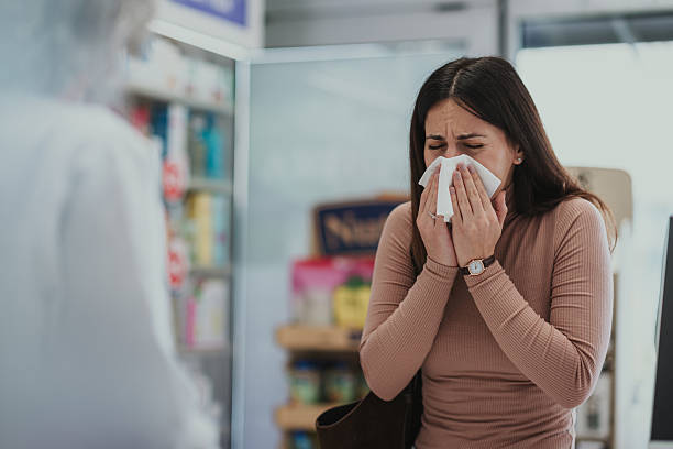 istock Young woman sneezing in pharmacy seeking cold relief 2249648270
