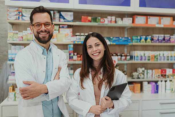 istock Pharmacists standing in pharmacy, smiling and looking at camera 2249648863