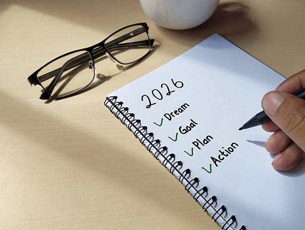 istock New year 2026 resolution concept. Goal, plan, action written on a notebook with wooden table background 2249654280