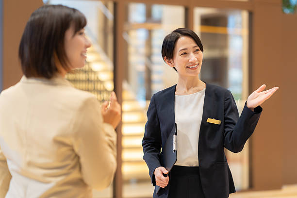 A female hotel attendant guiding a customer