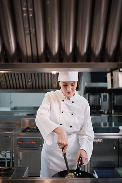 istock Female chef in white apron uniform cooking fried rice in restaurant kitchen. 2249659422