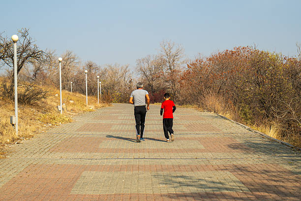 Yerevan Armenia 11.29.2025.  A man and a boy are running on a path