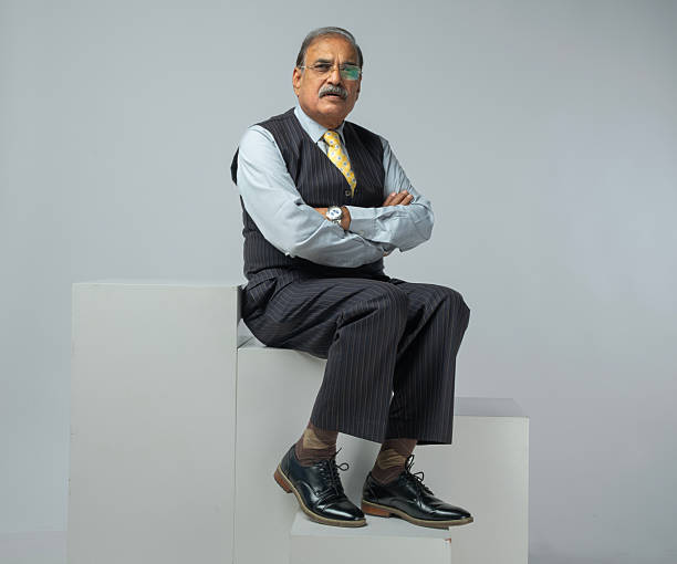 istock Elderly businessman sitting on block against white background 2249668601