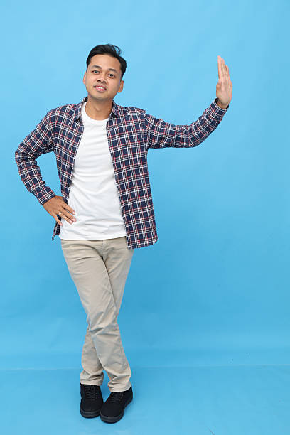 istock Young asian man leaning against wall isolated on blue background. 2249670271