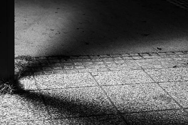 istock Shadow and Light on Textured Pavement in Black and White 2249673008
