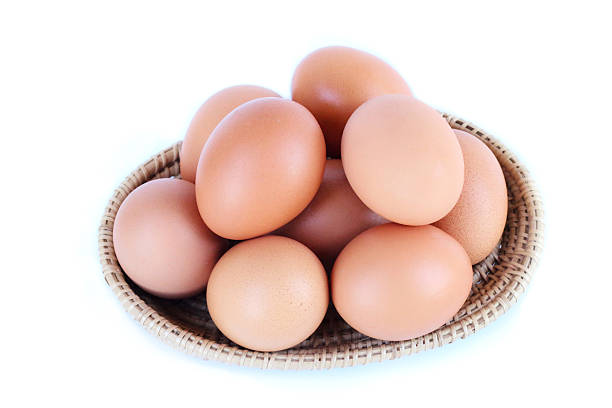 Chicken eggs stacked in a small woven basket top View, white background, clear and minimal style.