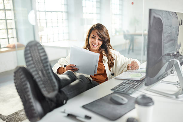 istock Happy female programmer working on PC and paperwork in the office. 2249676690