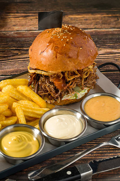 Slow-cooked beef brisket burger served with fries and sauces