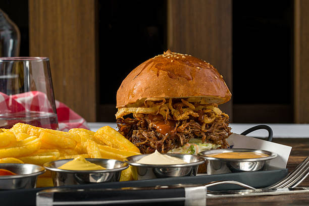 Slow-cooked beef brisket burger served with fries and sauces