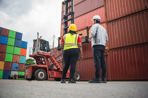 istock Diverse Logistics Engineers Observing Reach Stacker and Stacked Cargo Containers at Port Terminal, Supervisor and Foreman Checking Safety Protocols Before Loading Freight 2249680771