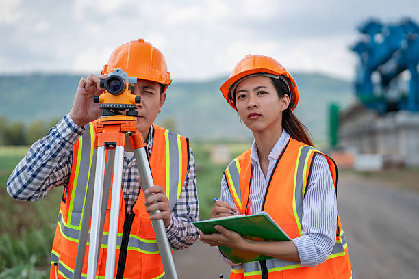 istock Civil engineers use surveying tools and a theodolite to measure and reference road construction plans during the ongoing project. 2249681253