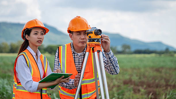 istock Civil engineers use surveying tools and a theodolite to measure and reference road construction plans during the ongoing project. 2249681339