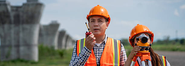 istock Civil engineers use surveying tools and a theodolite to measure and reference road construction plans during the ongoing project. 2249681359