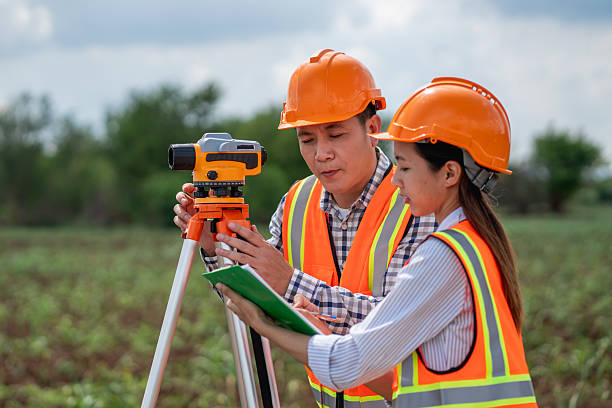 istock Civil engineers use surveying tools and a theodolite to measure and reference road construction plans during the ongoing project. 2249681876