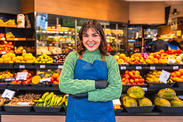 istock Smiling young woman working in a busy produce section 2249683651