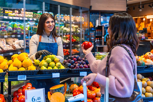 istock Supermarket employee helping customer choosing fresh fruit 2249683833