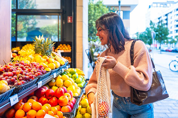 istock Young woman shopping for fresh fruit at grocery store 2249683880
