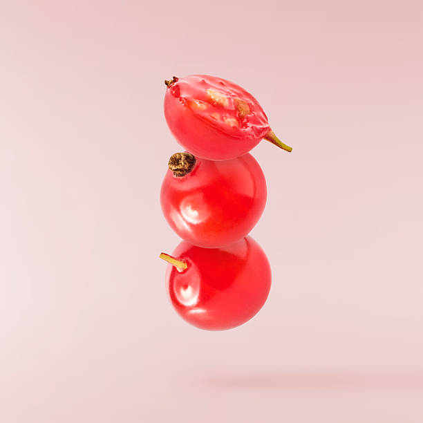 Fresh Ripe Red Currant berries falling in the air isolated on pink background