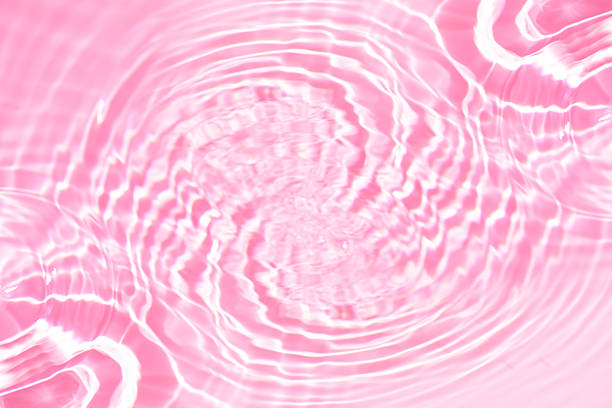 istock Pink water bubbles on the surface ripples. Defocus blurred transparent pink colored clear calm water surface texture with splash and bubbles. Water waves with shining pattern texture background 2249685706