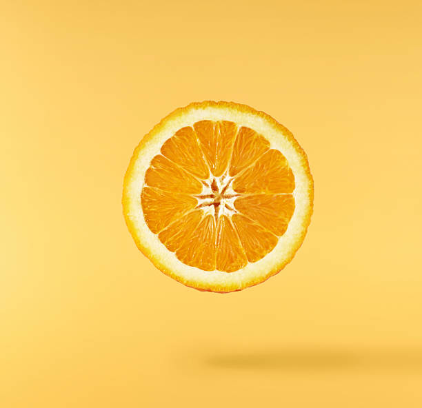 istock Fresh juicy orange slices floating on a vibrant yellow background. Creative citrus levitation concept for healthy food, summer vibes, advertising, packaging, and design projects. 2249686600