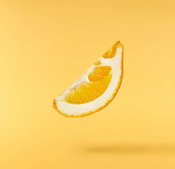 istock Fresh juicy orange slices floating on a vibrant yellow background. Creative citrus levitation concept for healthy food, summer vibes, advertising, packaging, and design projects. 2249686603
