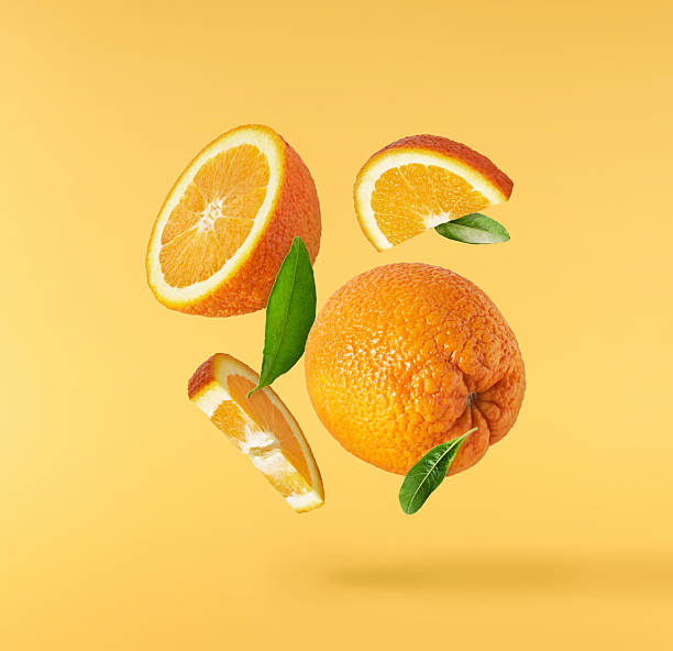 istock Fresh juicy orange slices floating on a vibrant yellow background. Creative citrus levitation concept for healthy food, summer vibes, advertising, packaging, and design projects. 2249686607