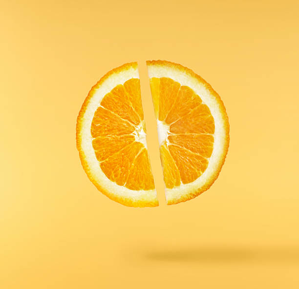 istock Fresh juicy orange slices floating on a vibrant yellow background. Creative citrus levitation concept for healthy food, summer vibes, advertising, packaging, and design projects. 2249686652