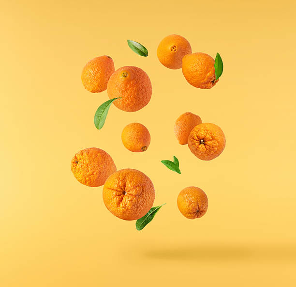istock Fresh juicy orange floating on a vibrant yellow background. Creative citrus levitation concept for healthy food, summer vibes, advertising, packaging, and design projects. 2249686659