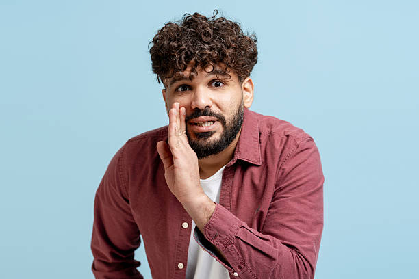 istock Man whispering secret or gossip, sharing confidential information on blue background 2249688278