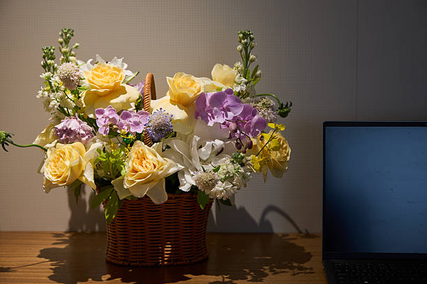 Woven baskets filled with colorful flowers create a lively display in an indoor garden setting. The arrangement adds charm to the space during a bustling community event.