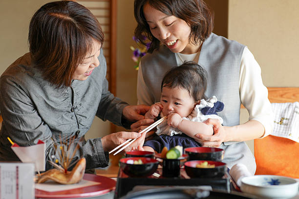 istock A woman is feeding a baby with chopsticks 2249689263