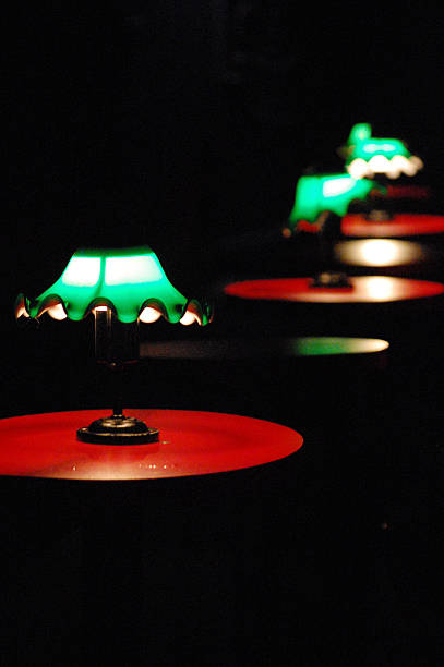 istock Green lamps on red tables in a dimly lit setting 2249690847