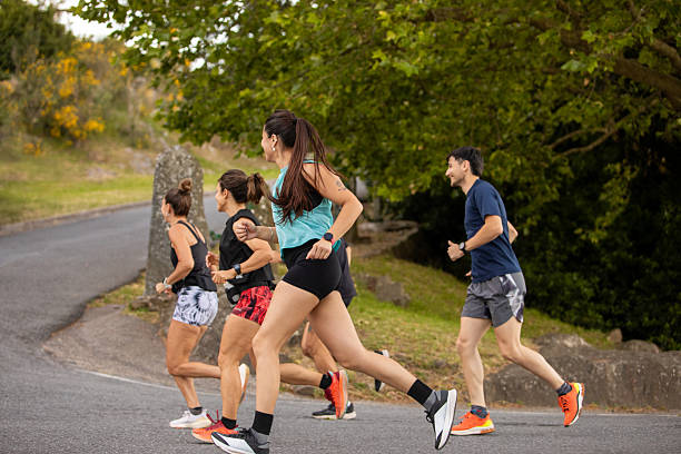 istock Group of running friends running in a public park 2249690879