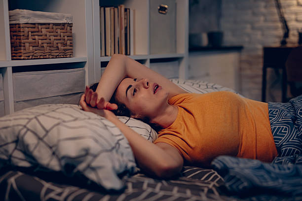 istock Exhausted woman resting in bed, unable to fall asleep 2249691743