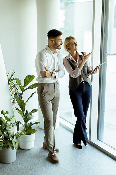 istock Discussing ideas by the window in a modern office setting during daylight hours 2249693616