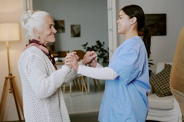 istock Senior Woman Smiling While Holding Hands with Young Hispanic Nurse 2249696097