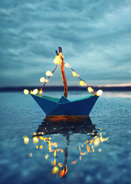 istock frozen sea with blue paper boat with lantern at the beach - romantic evening 2249696804