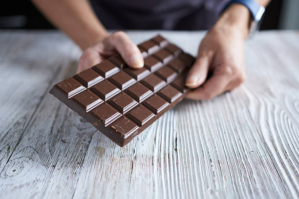 istock Dark chocolate. A bar of dark chocolate in a woman's hand. 2249697717