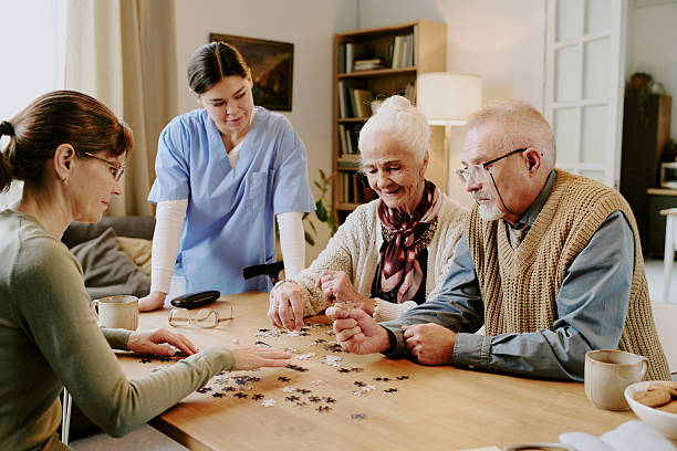 istock Senior Couple Solving Puzzle with Young Female Nurse Observing 2249697855