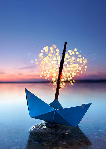 istock magical blue paper boat with lantern at the beach - romantic evening 2249697918