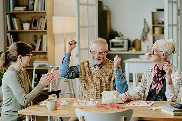 istock Senior Man Celebrating Victory While Playing Board Game with Friends 2249698064