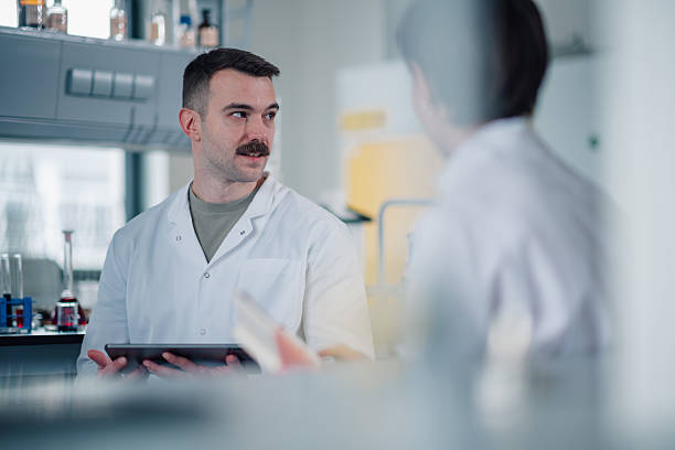 istock Male scientist discussing research holding digital tablet in lab 2249698145