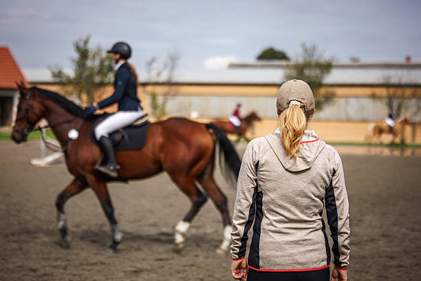 Riding School. Riders and black horses in the city park.