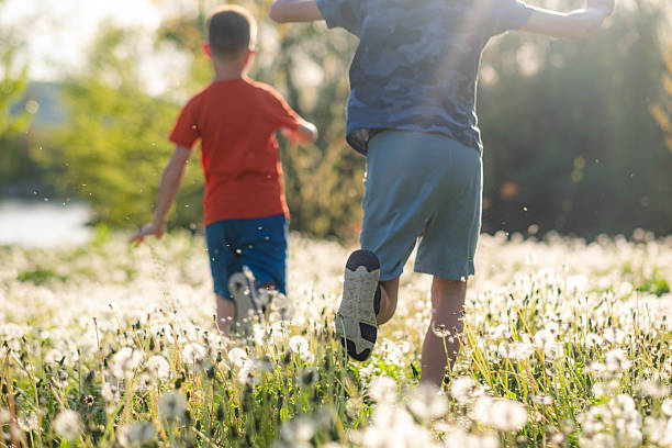 istock Two boys running through dandelions in summer field 2249700851