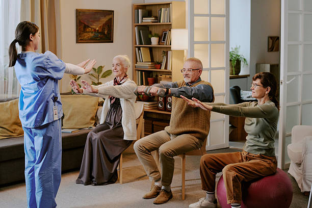 istock Middle Aged Woman Guiding Seniors Exercising during Group Session 2249703476